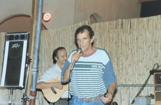 Chanson au micro, un guitariste à ses côtés