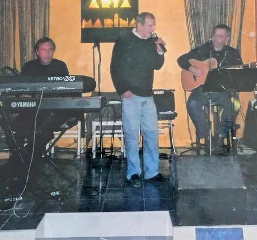 Au micro, entre un clavier et un guitariste