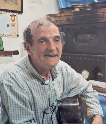 Hubert Tempête souriant, la guitare à la main