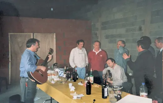 Une tablée, un guitariste debout